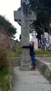 Me with my arms wrapped around a large stone cross.