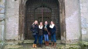 Three of my friends and I standing outside a gate of the castle.