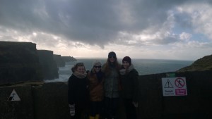 The four girls standing with the cliffs in the background.