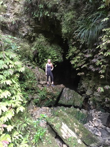 Standing in front of a cave that lead way back behind the greenery